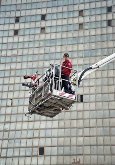 A firefighter of Taipei City Fire Department in a hydraulic platform during a fire drill.